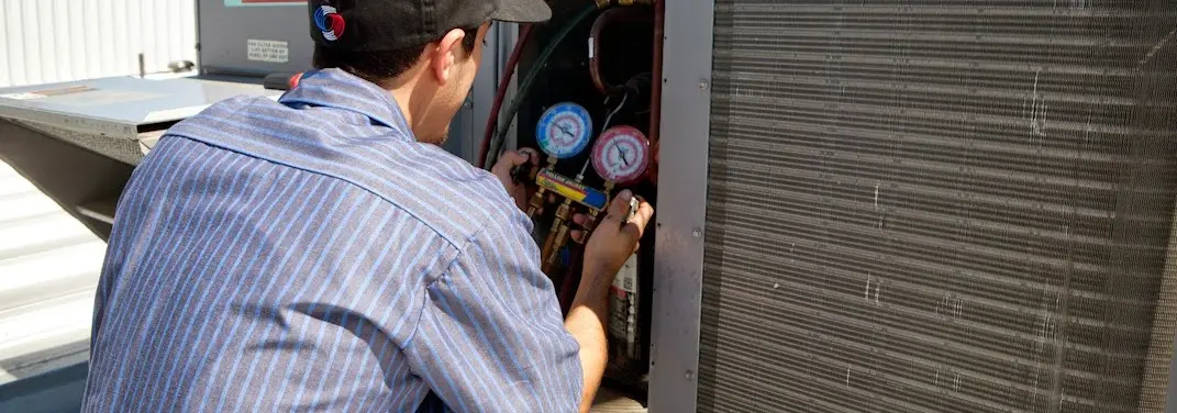 HVAC technician servicing a condenser unit in Upper Merion